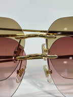 Gold metal round sunglasses with tinted lenses and sleek curved bridge.