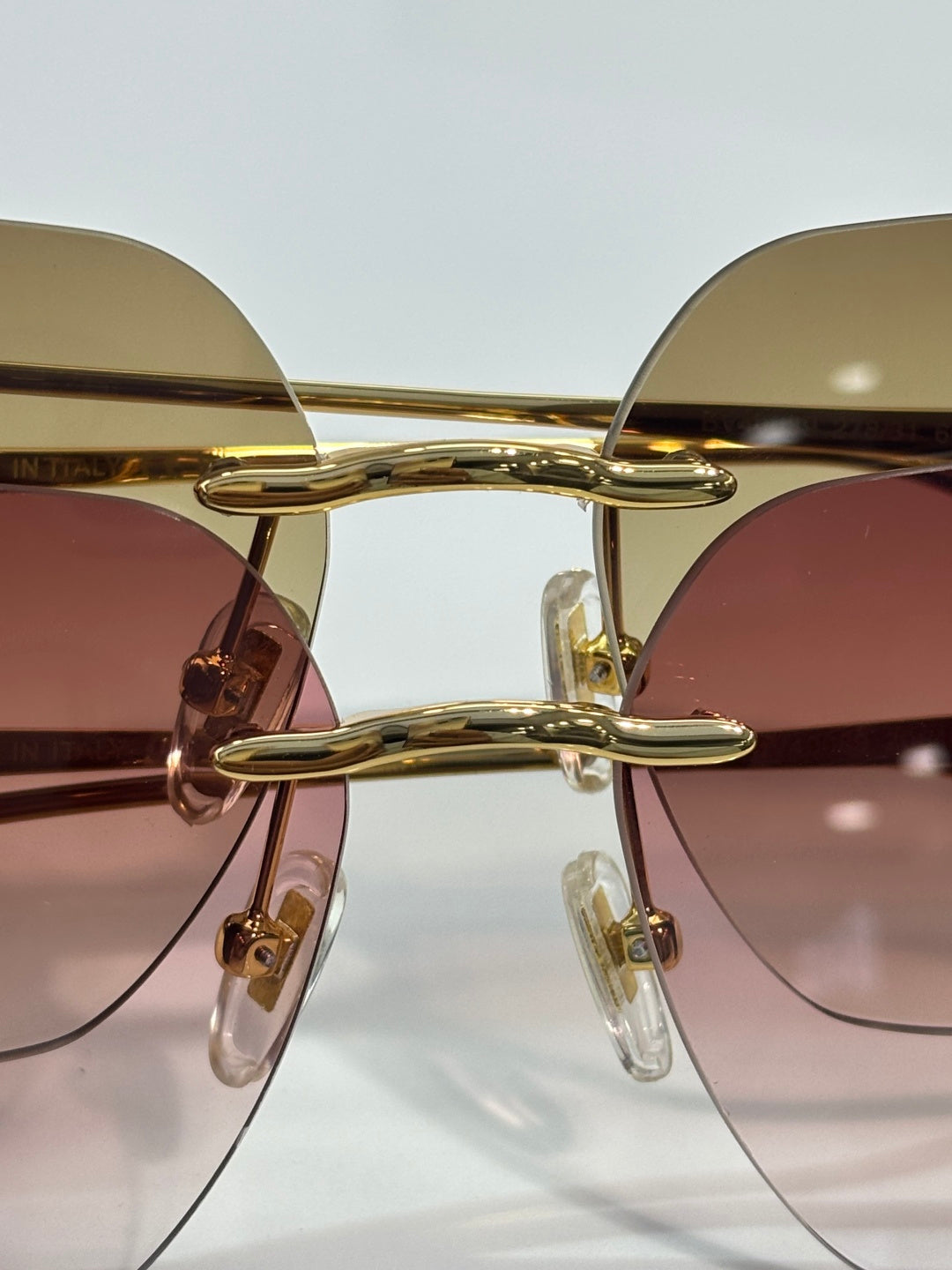 Gold metal round sunglasses with tinted lenses and sleek curved bridge.