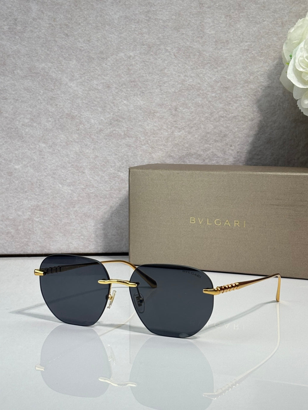 Gold metal round sunglasses with dark lenses and black temples, thin frame.