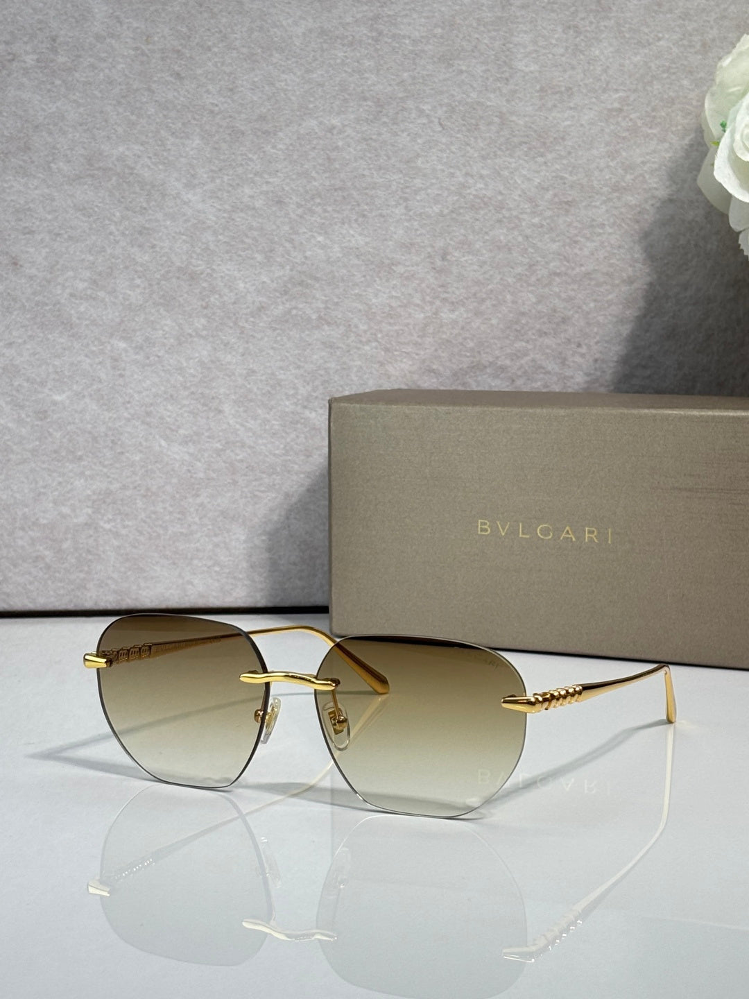 Gold metal round sunglasses with light lenses and clear-to-brown bridge detail.