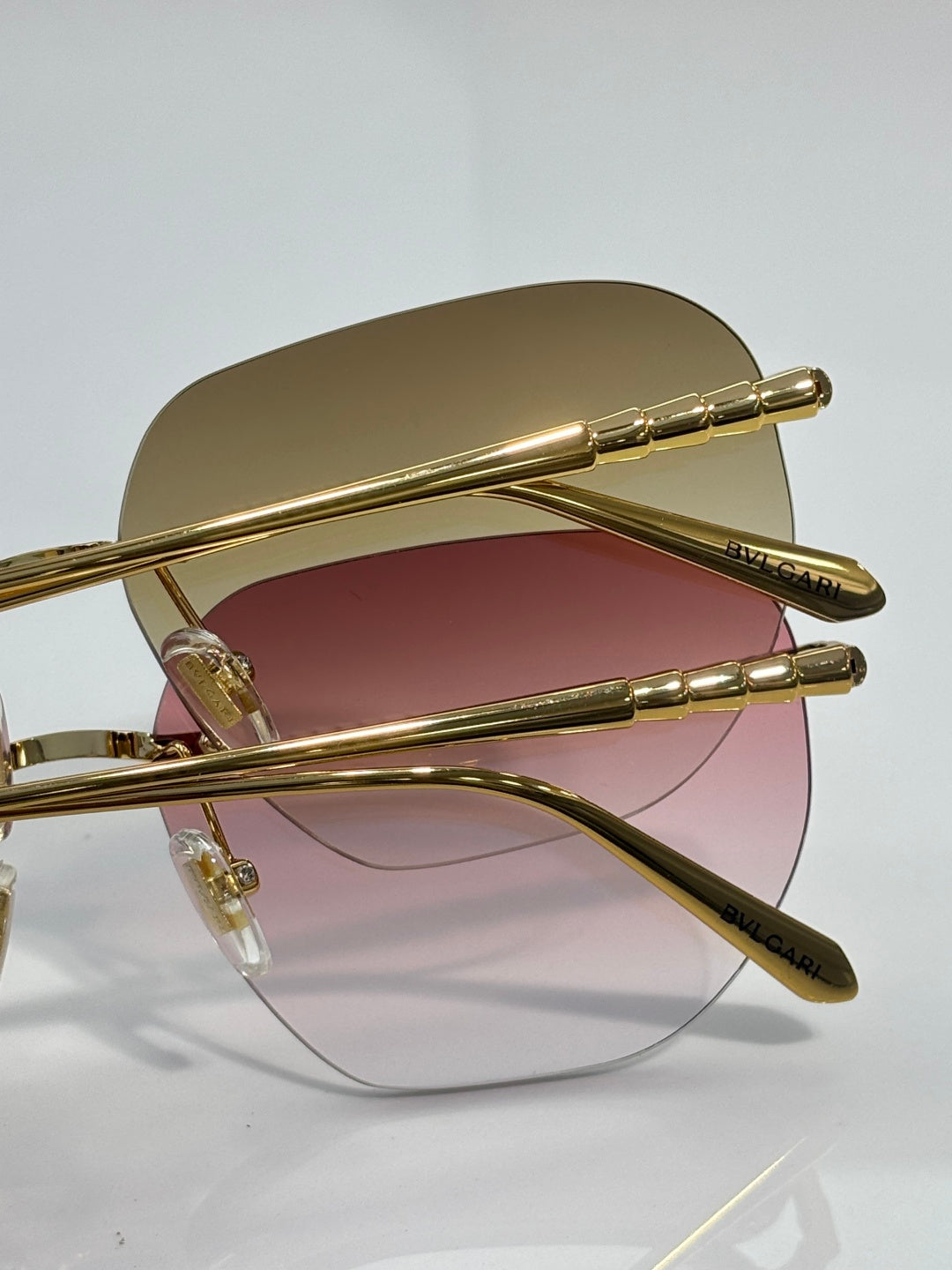 Gold metal round sunglasses with rose-tinted lenses and slim articulated temples.
