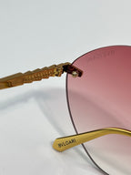 Close-up of burgundy lens and gold-tone hinge with engraved branding