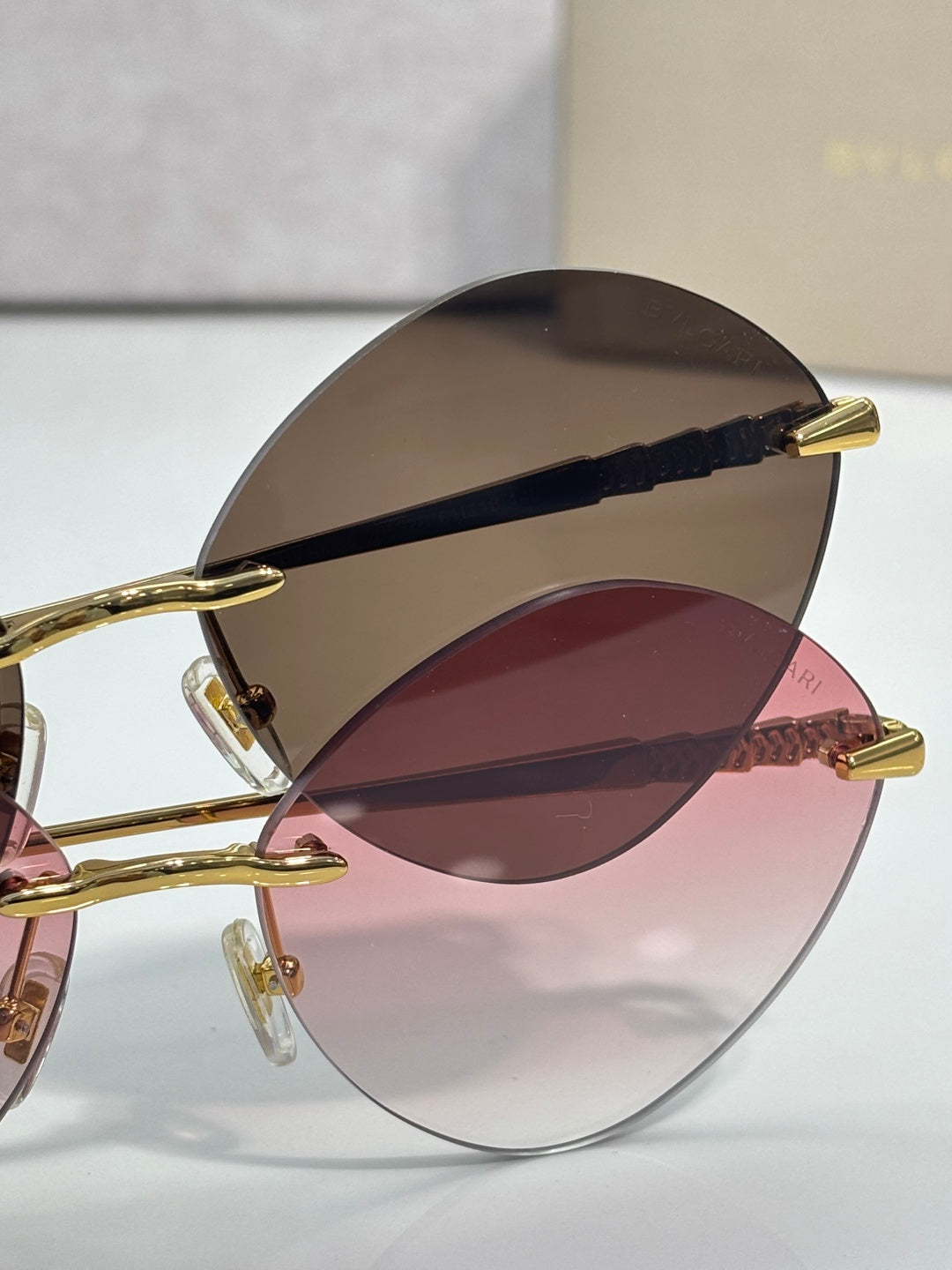 Round oversized sunglasses with gold-tone arms and dark-to-burgundy lenses