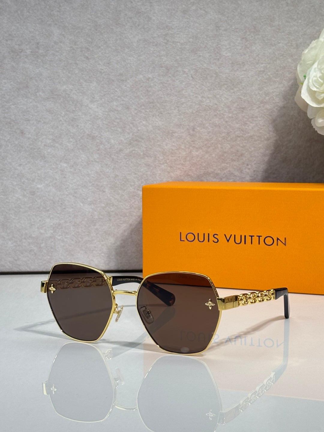 Louis Vuitton sunglasses with gold-tone frame, dark tinted lenses, logo temple details