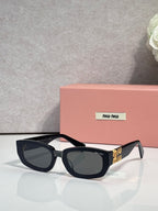 MiuMiu sunglasses with dark frames and blue-tinted cat-eye lenses