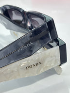 Prada glasses temple arm close-up with PRADA engraving and hinge detail
