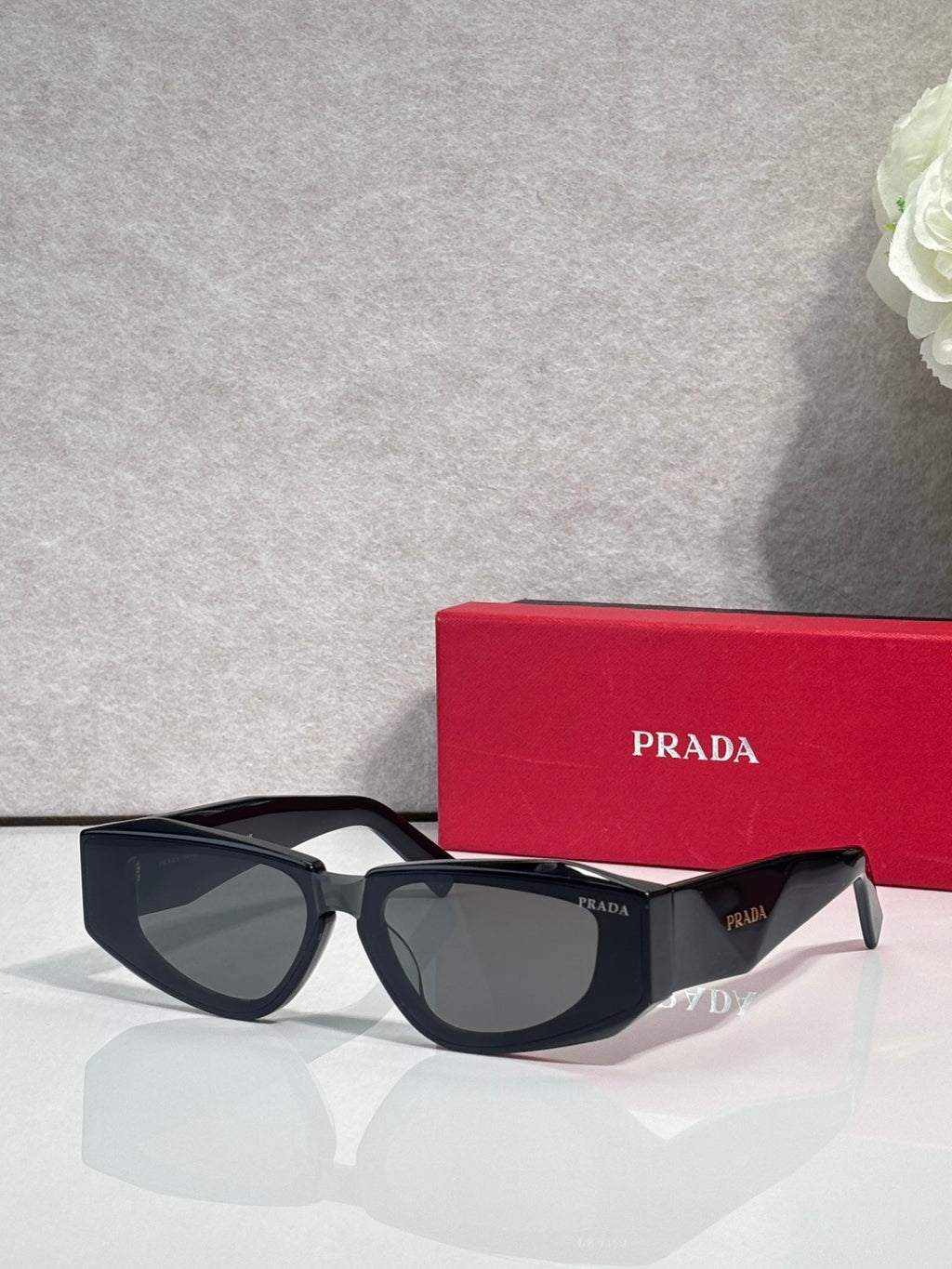 Prada glasses with black frames and tinted lenses, front view with temple logo