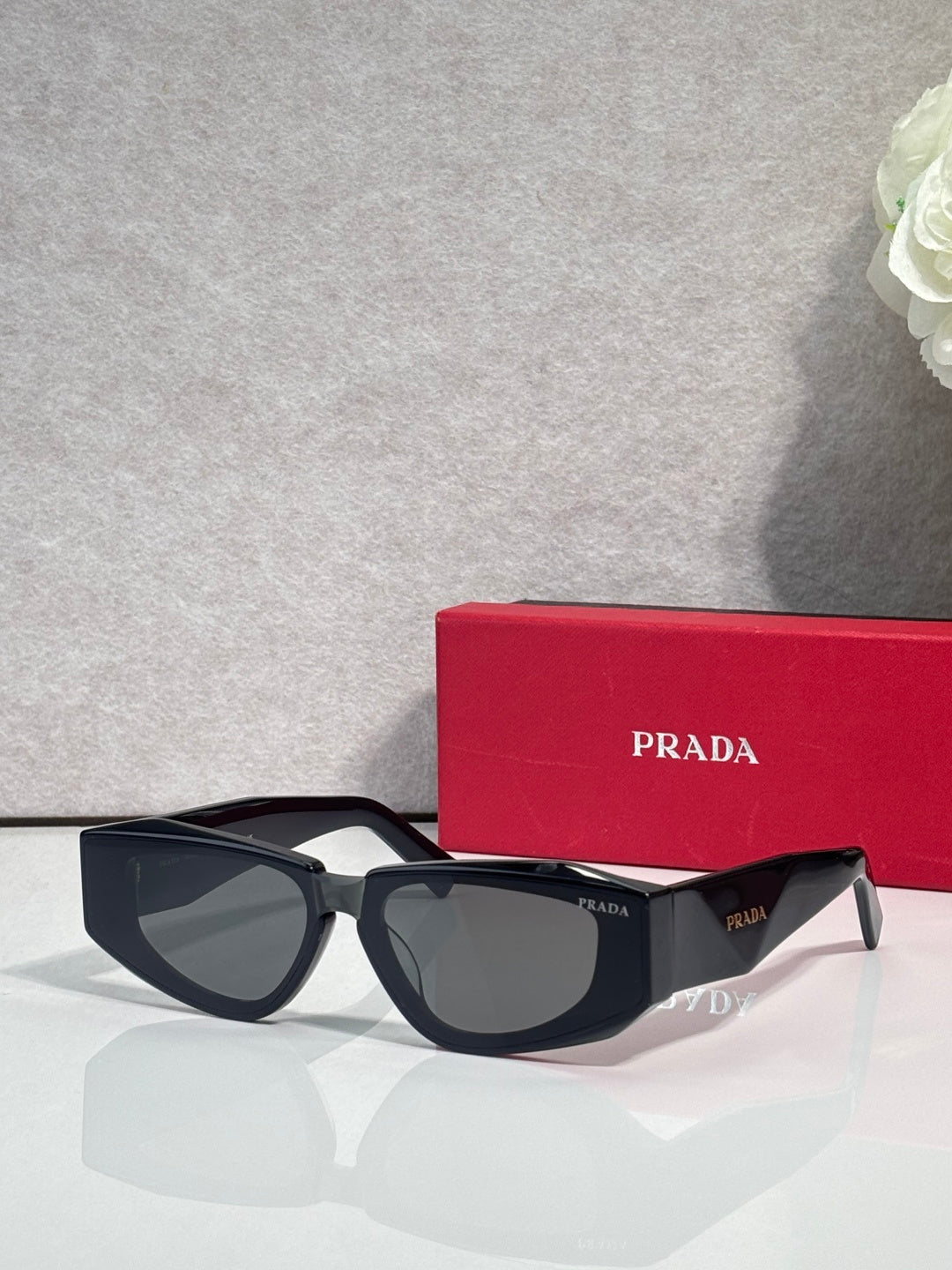 Prada glasses with black frames and tinted lenses, front view with temple logo