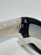 Prada glasses hinge and temple arm close-up, glossy dark frame