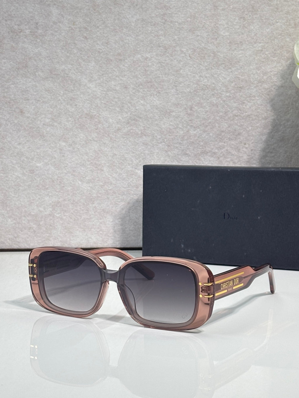 Dior sunglasses with rose gold square frames and dark tinted lenses