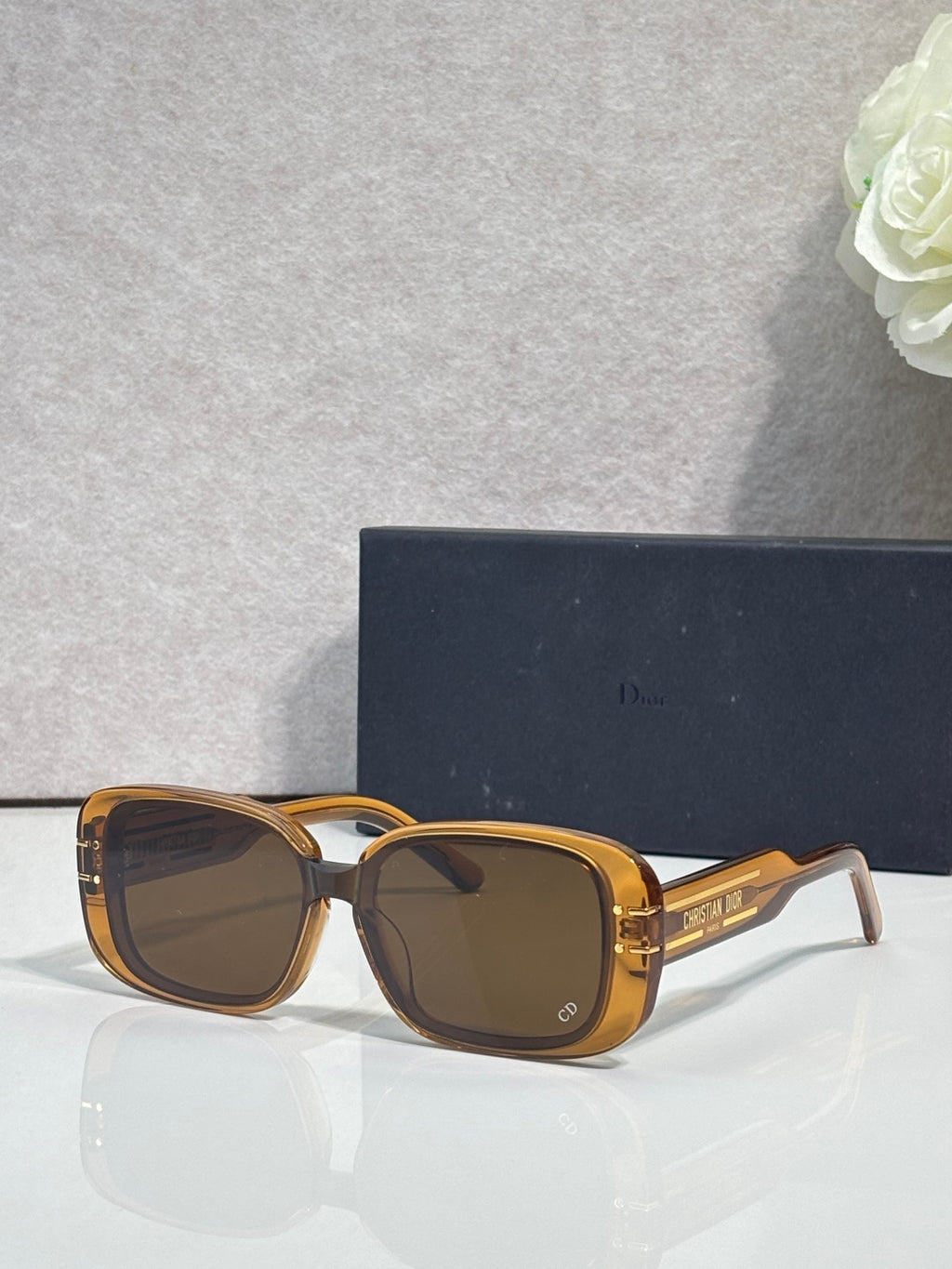 Dior sunglasses with amber square frames and dark tinted lenses