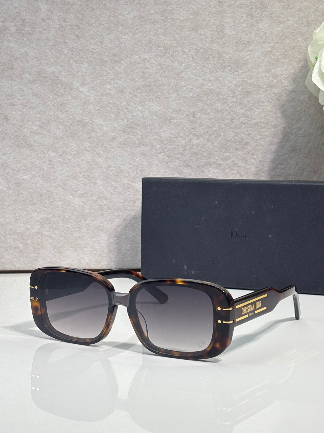 Dior sunglasses with tortoiseshell square frames and dark tinted lenses