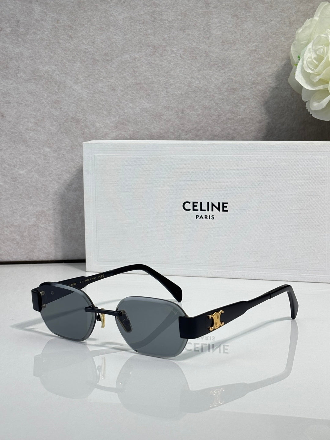 Celine sunglasses with dark frames, oval dark lenses, and gold-tone emblem on temples