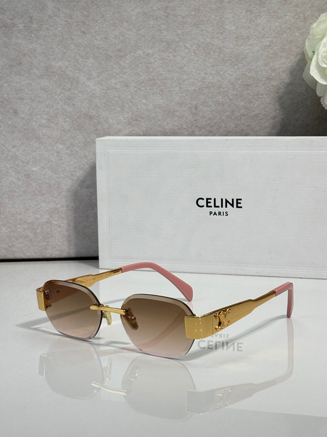 Celine sunglasses with brown frames, gradient lenses, and pink/red temples with gold logo