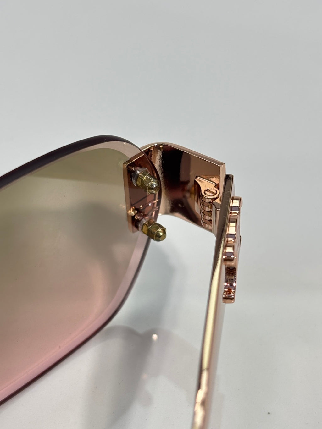 Celine sunglasses close-up of gold-tone hinge and temple hardware near the lens