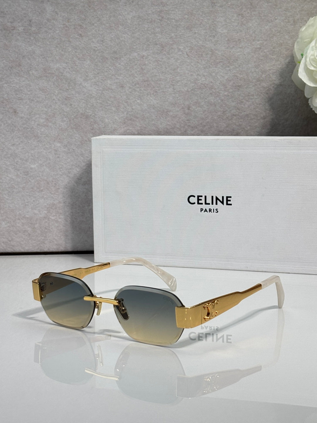 Celine sunglasses with gold-beige frames, dark lenses, and clear-style temple tips