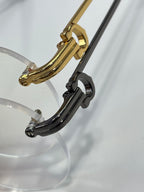 Gold and black eyeglass frame with clear lenses, curved temple detail