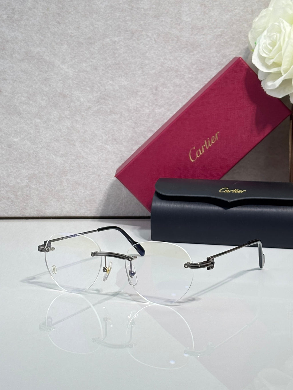 Metal eyeglasses with clear lenses, dark navy frame and gold hinge accents