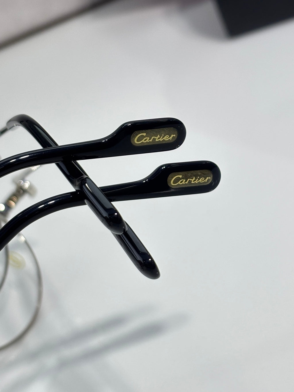 Cartier eyeglasses temple close-up, black arms with Cartier branding in gold