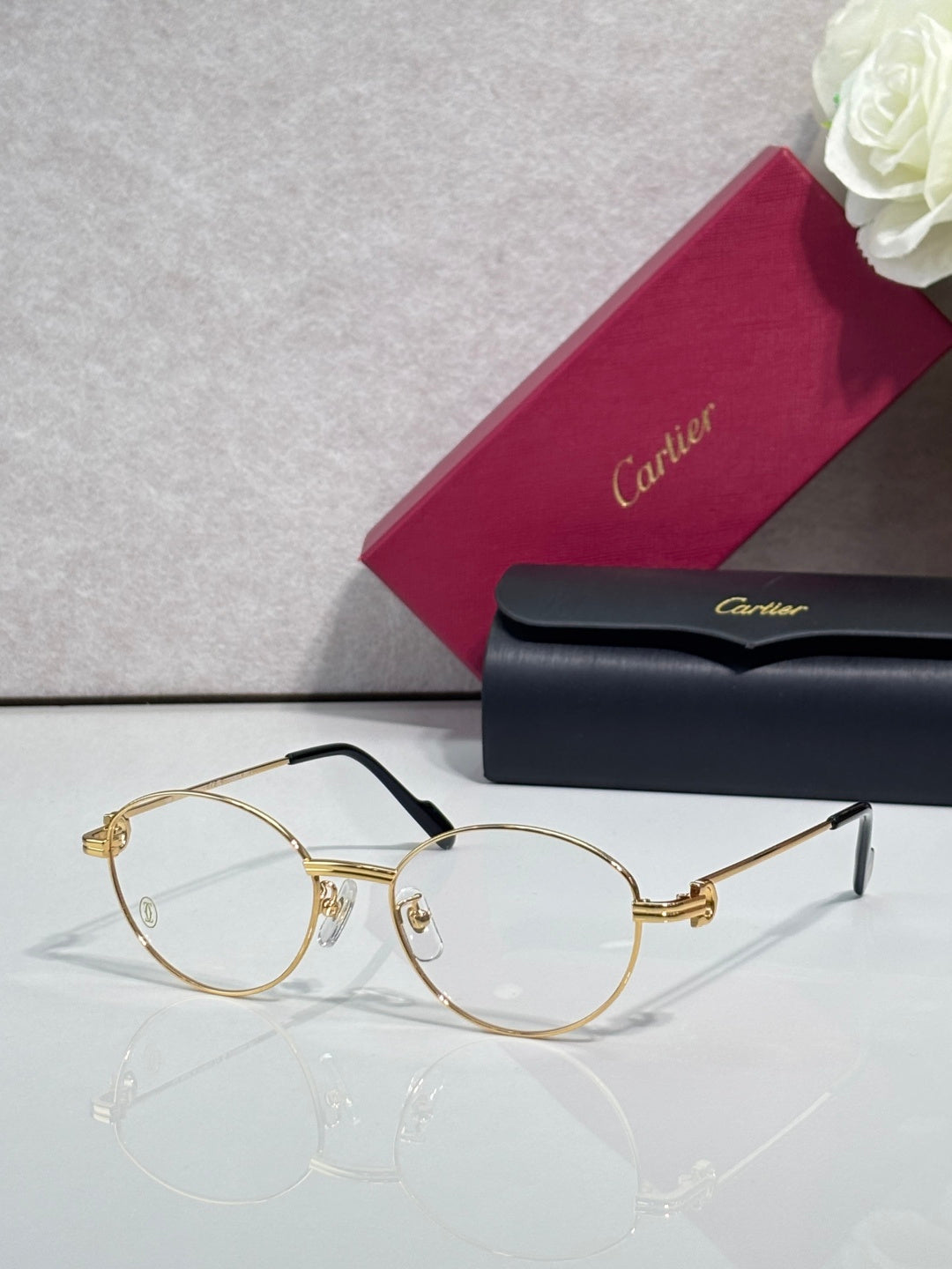 Cartier eyeglasses, round clear lenses, thin gold metal frame with gold logo