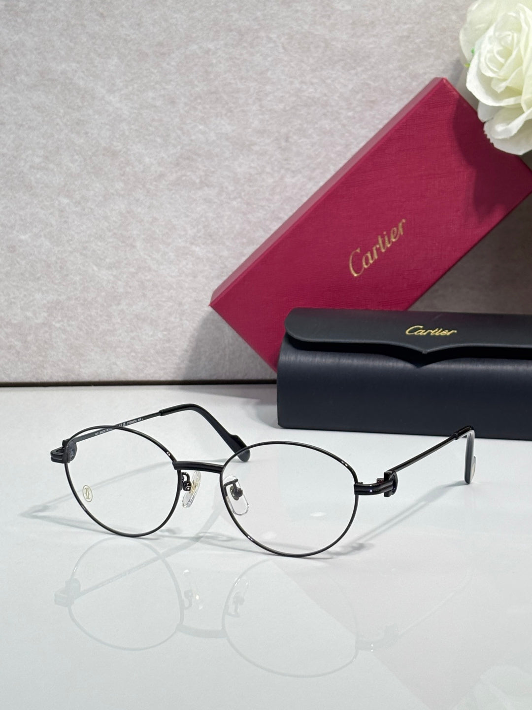 Cartier eyeglasses, round clear lenses, thin dark frame with black temple arms
