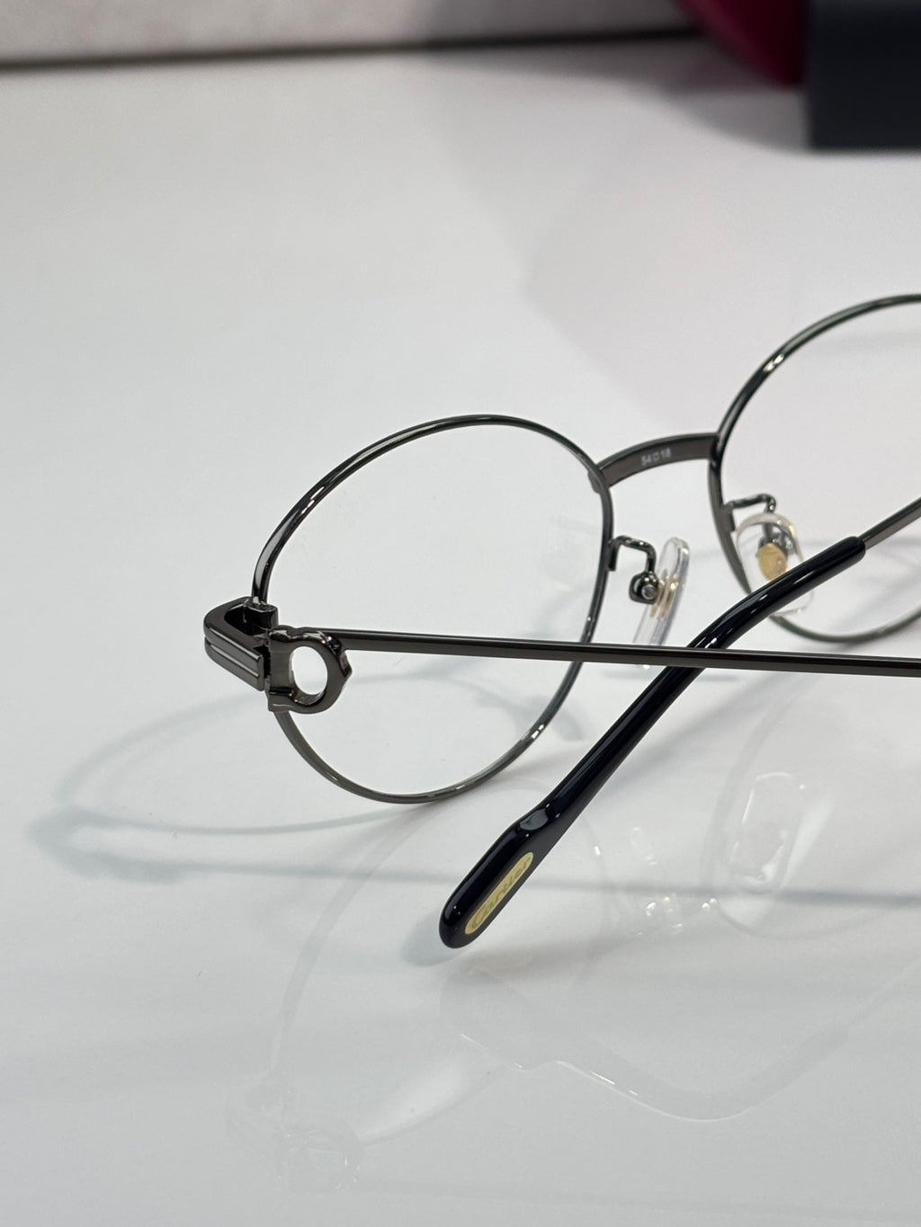 Round metal eyeglasses close-up of left lens and bridge with clear optics