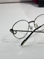 Round metal eyeglasses close-up of left lens and bridge with clear optics