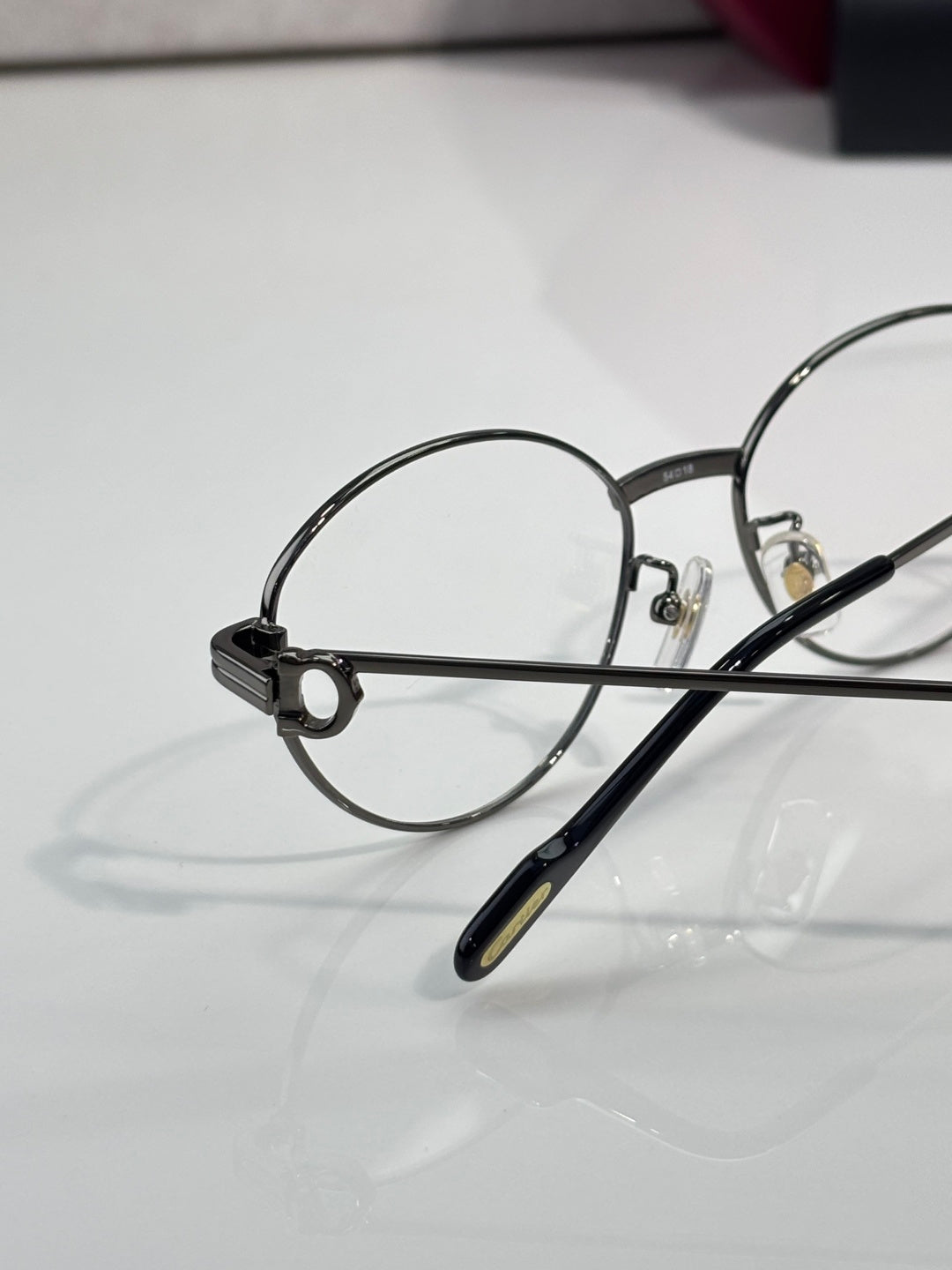 Round metal eyeglasses close-up of left lens and bridge with clear optics