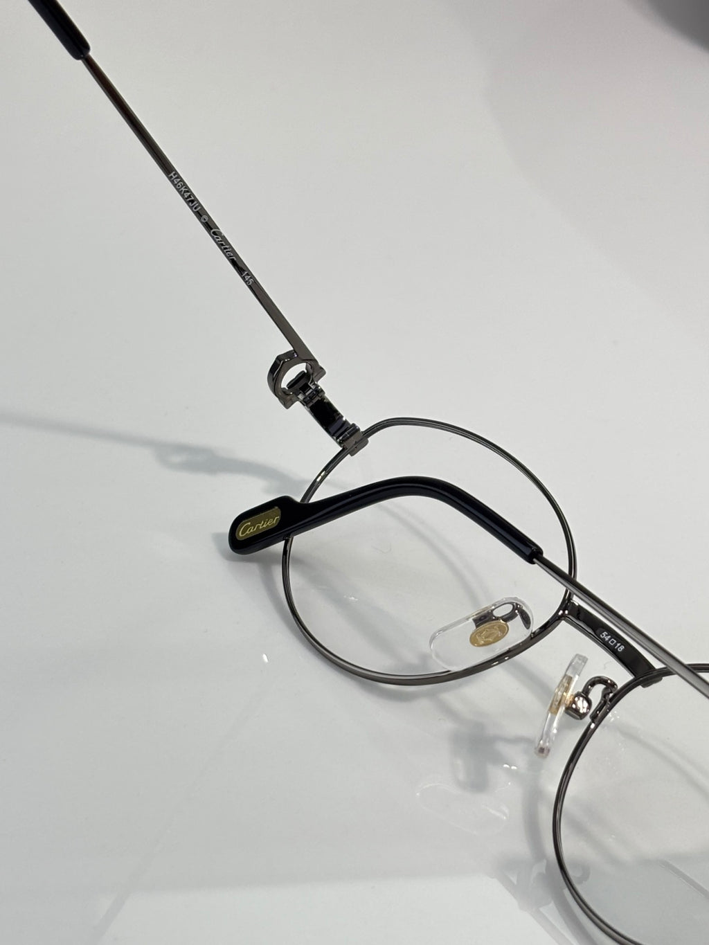 Round metal eyeglasses angled view with clear lens and black temple tips