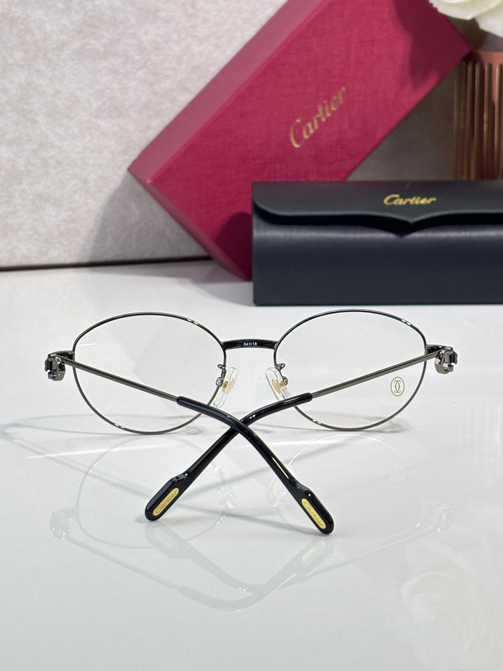 Round metal Cartier eyeglasses front view with clear lenses and black temples
