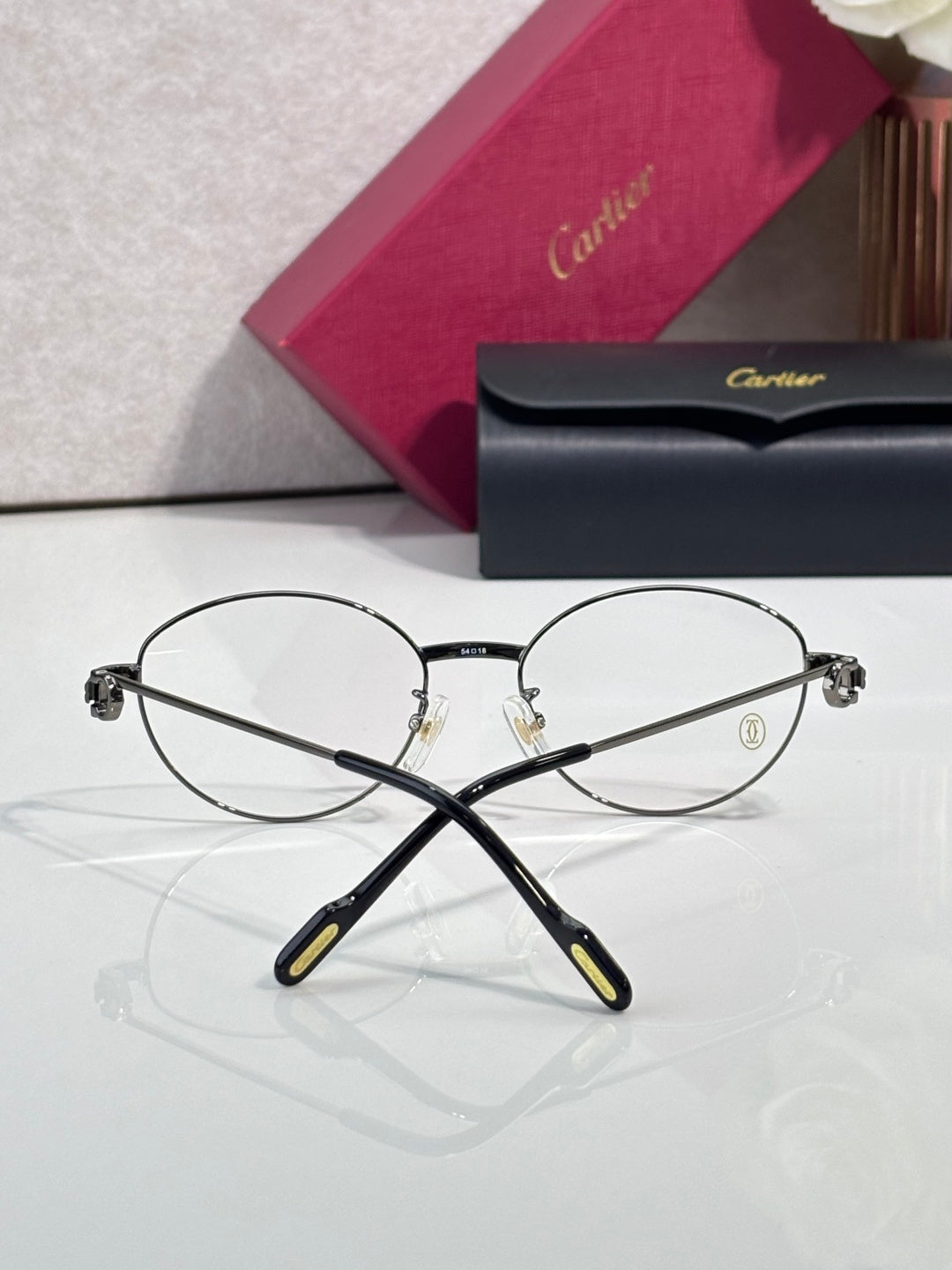 Round metal Cartier eyeglasses front view with clear lenses and black temples