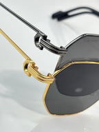 Cartier sunglasses close-up with gold and black temples and dark round lens