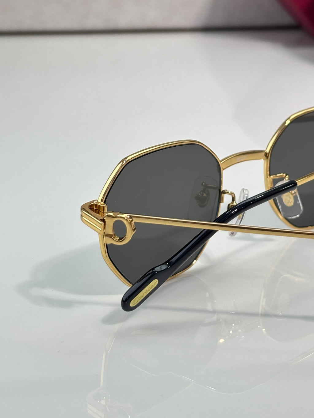 Cartier oval sunglasses with gold-tone frame and dark lenses, side profile