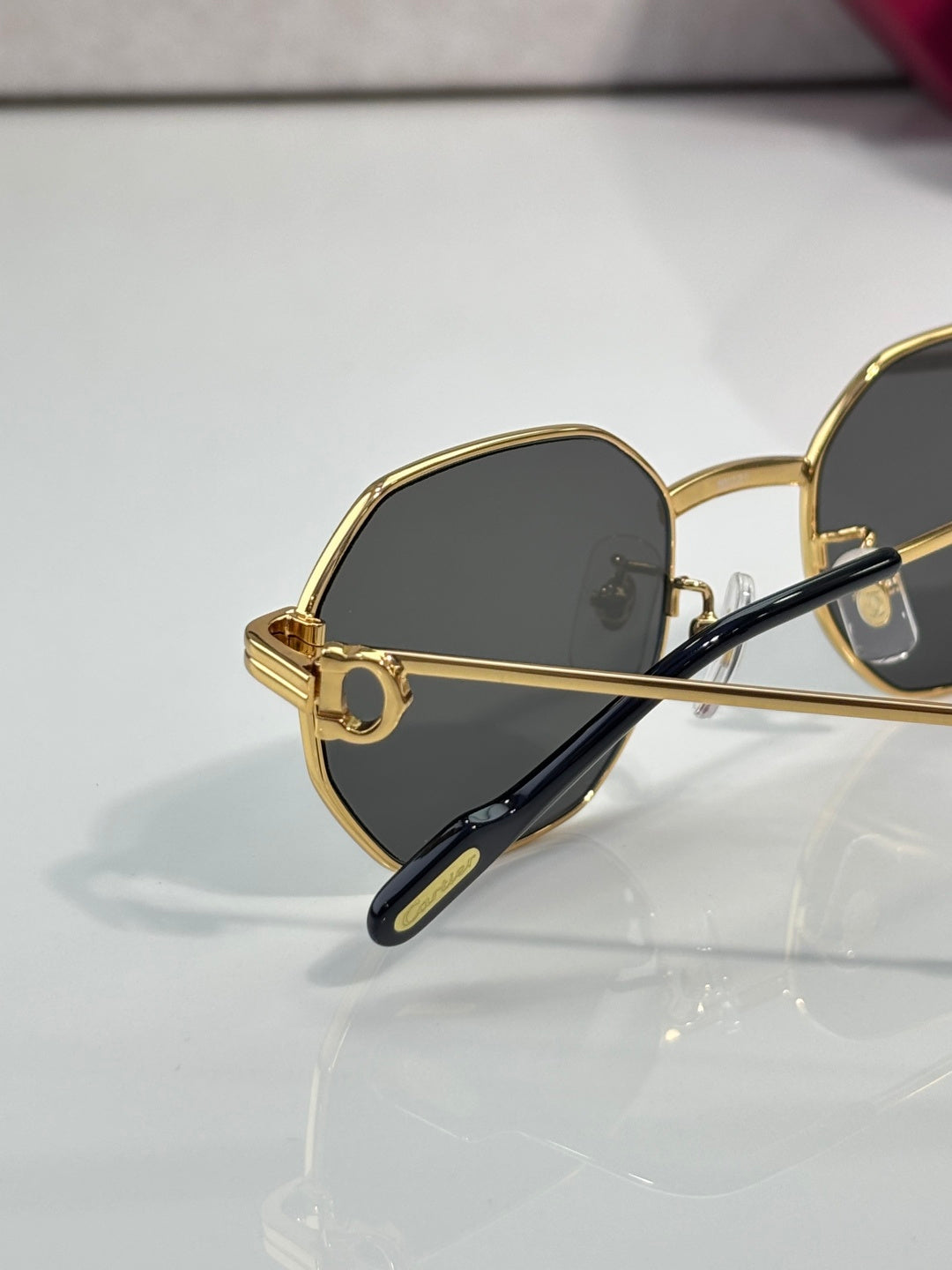 Cartier oval sunglasses with gold-tone frame and dark lenses, side profile