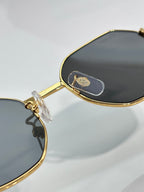Cartier oval sunglasses with gold-tone frame and dark lens, logo on arm