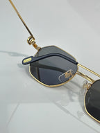 Cartier oval sunglasses with gold-tone frame and dark lenses, temple detailing