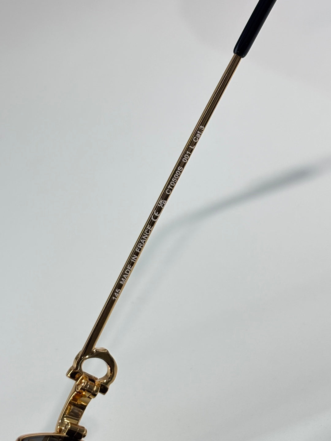 Cartier eyeglasses temple with engraved text and gold-tone metal arm