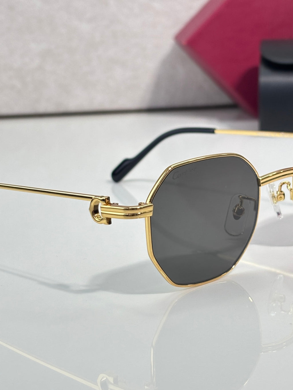 Cartier oval sunglasses with gold-tone frame and dark tinted lens, side view