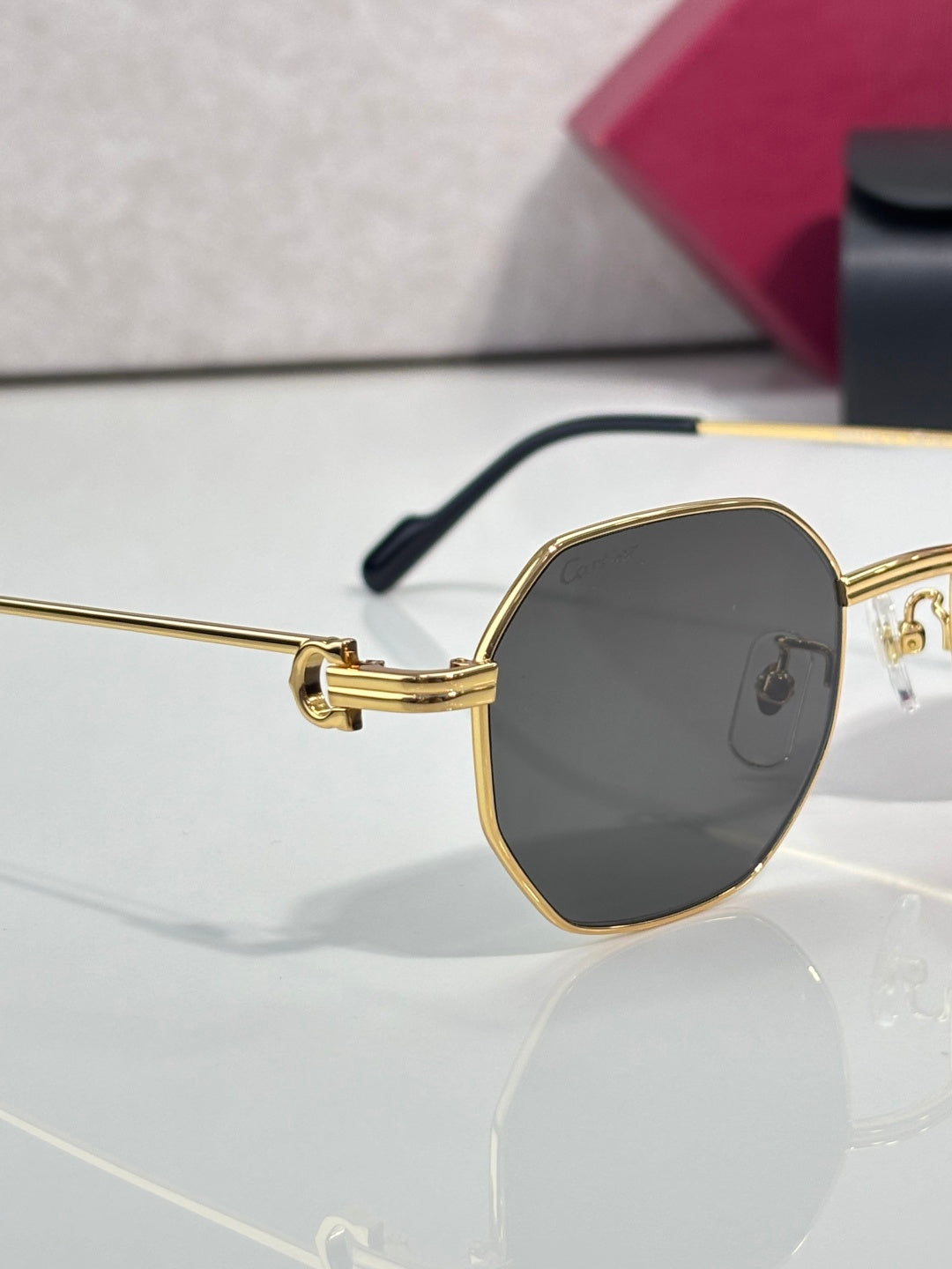 Cartier oval sunglasses with gold-tone frame and dark tinted lens, side view
