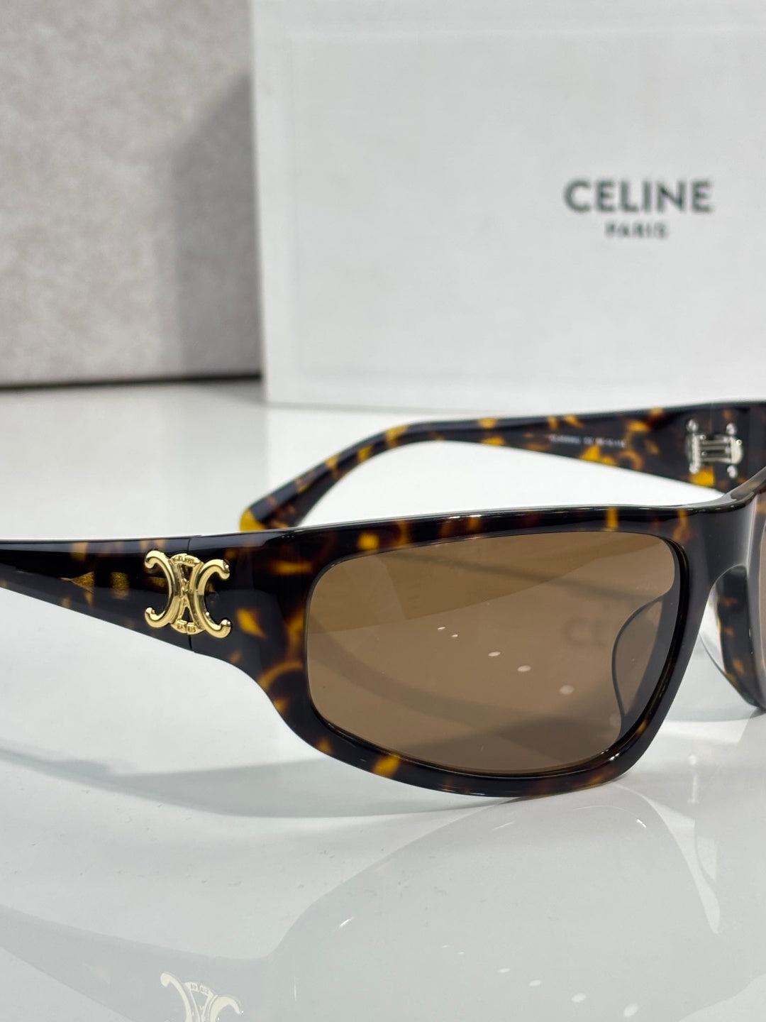 Celine tortoiseshell sunglasses with gold emblem on arm and dark tinted lenses
