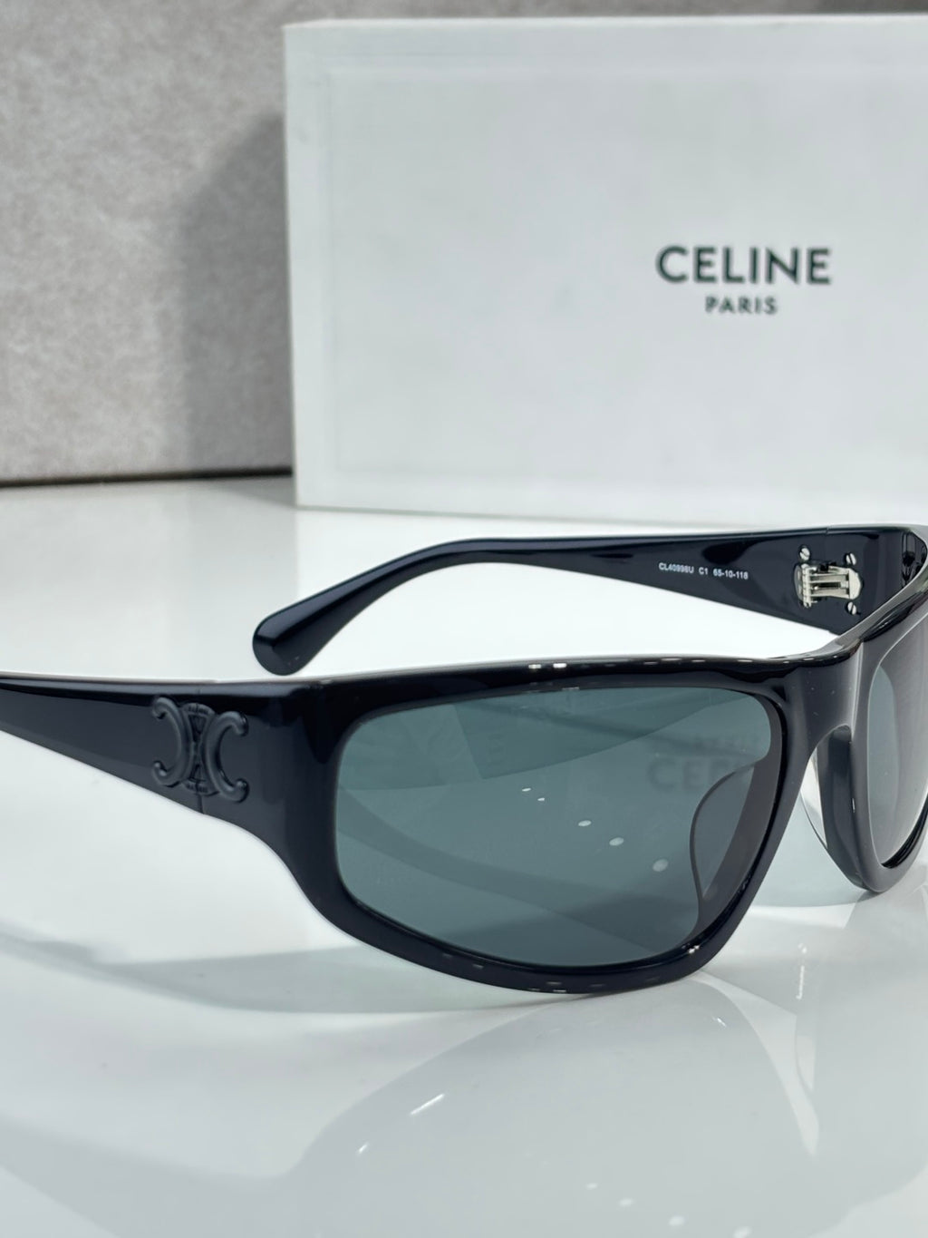 Celine sunglasses with dark frames and tinted dark green lenses, side profile view