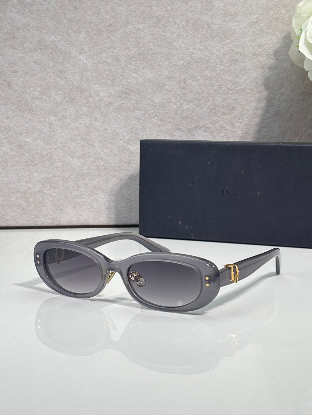 Dior dark gray oval sunglasses with gray lenses and gold-tone emblem