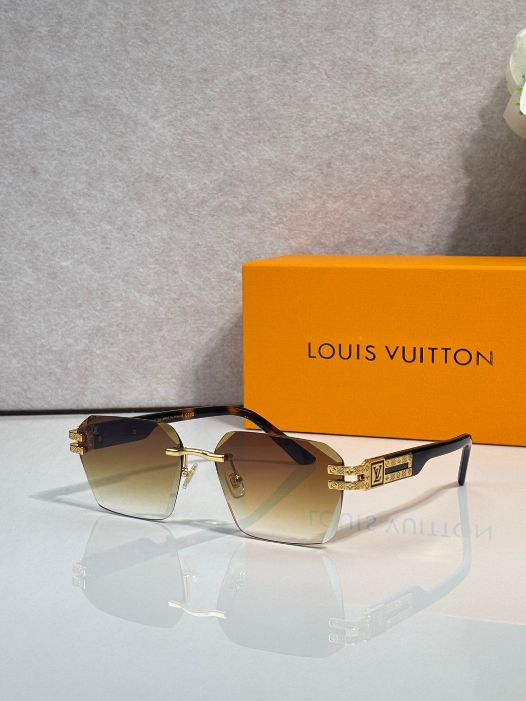 Louis Vuitton glasses with dark brown frames and amber gradient lenses, gold hardware