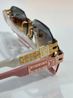 Louis Vuitton glasses close-up with pink temples, gold LV bar, and gradient dark lenses