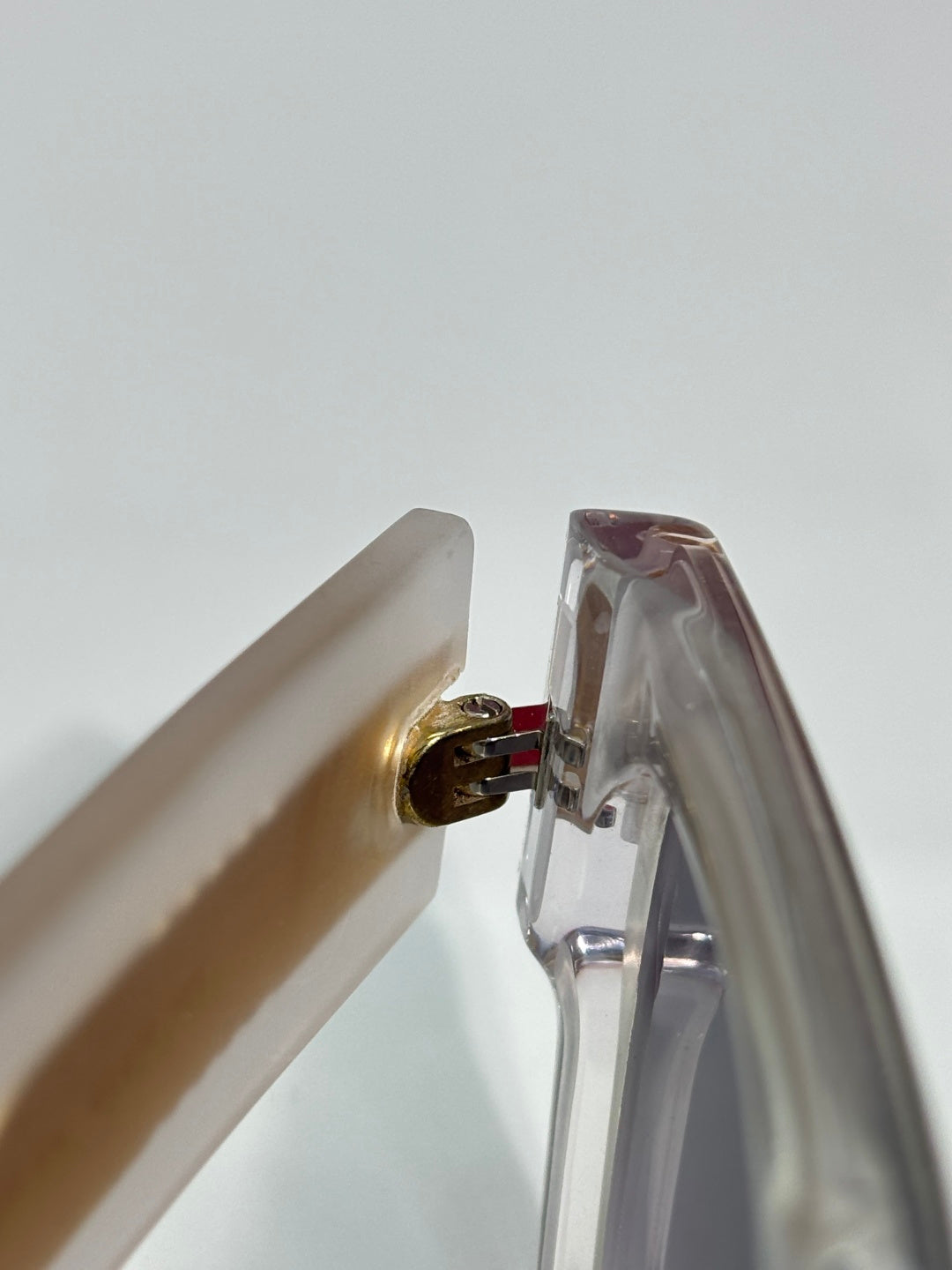 Clear sunglasses hinge with gold-tone screw detail