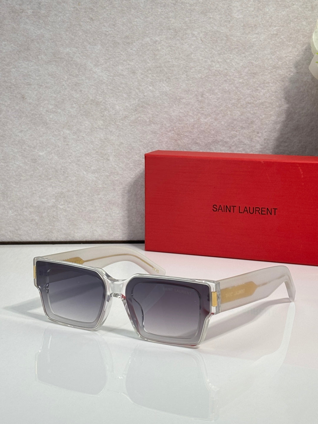 Square clear sunglasses with dark lenses and gold-tone bridge accents