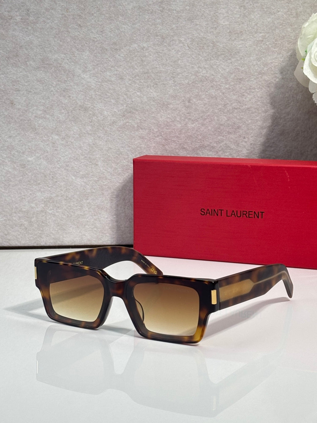 Square tortoiseshell sunglasses with warm brown lenses and gold accent at temple