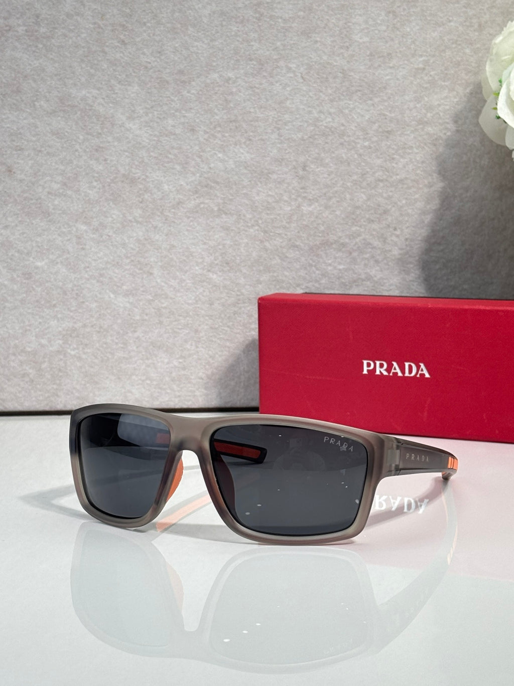 Prada sunglasses with dark lenses and dark tortoise frame, with red Prada case