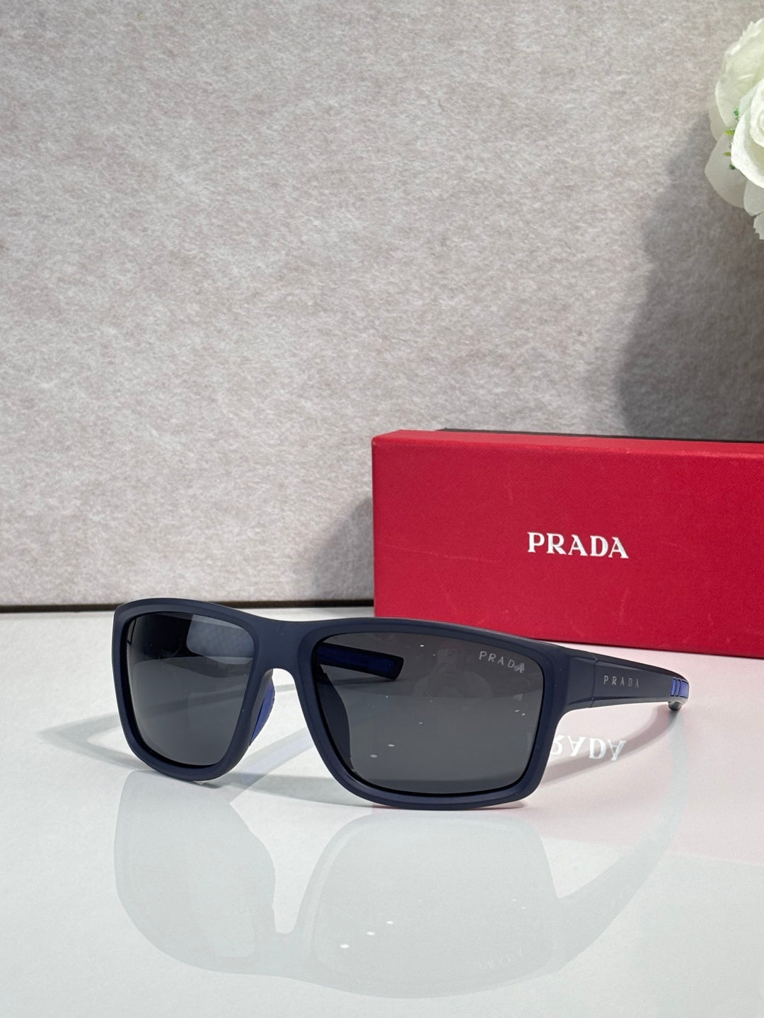 Prada sunglasses with dark lenses and black frame, with red Prada case