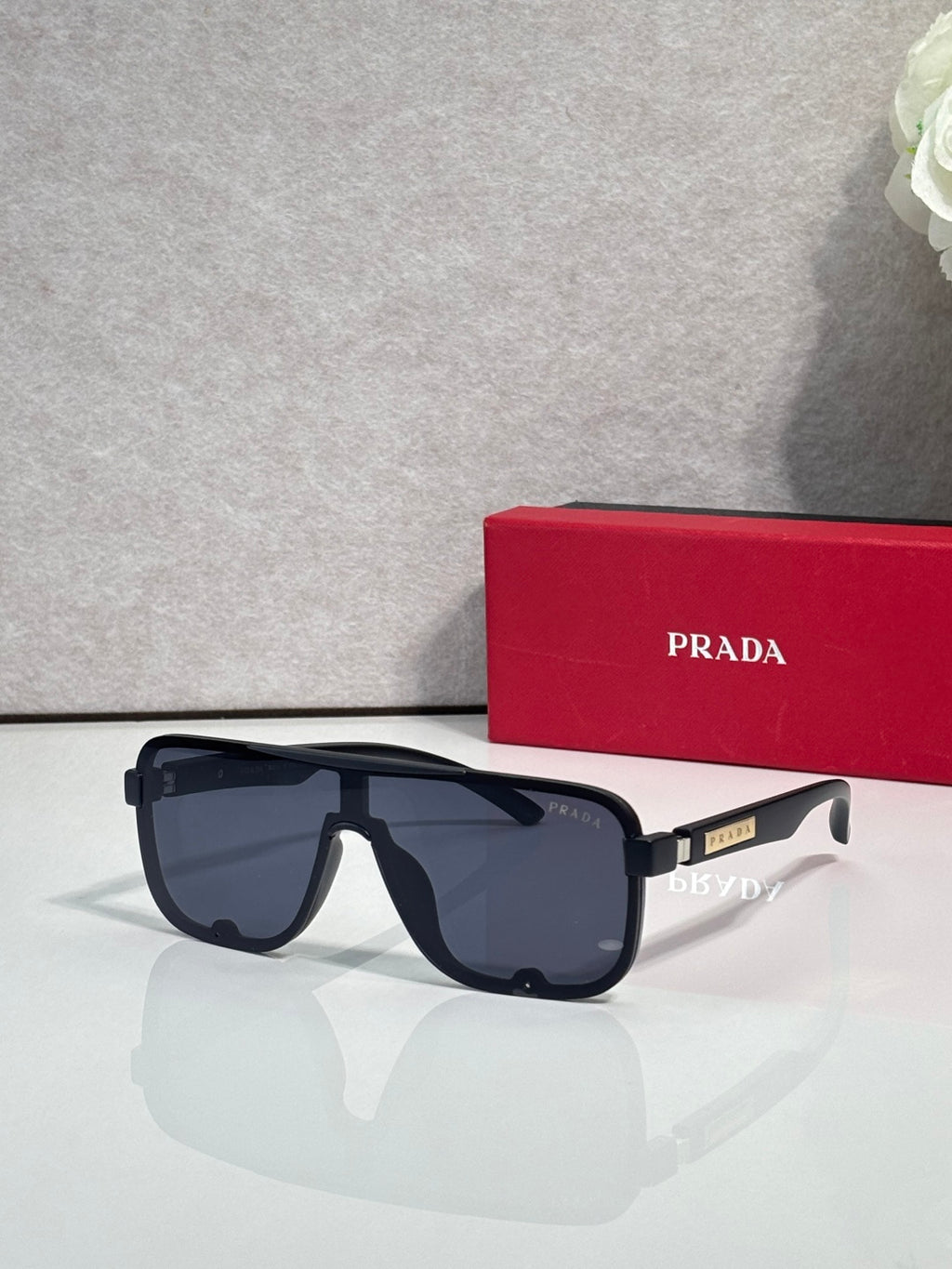 Prada rectangular sunglasses with dark frames and tinted lenses, front view